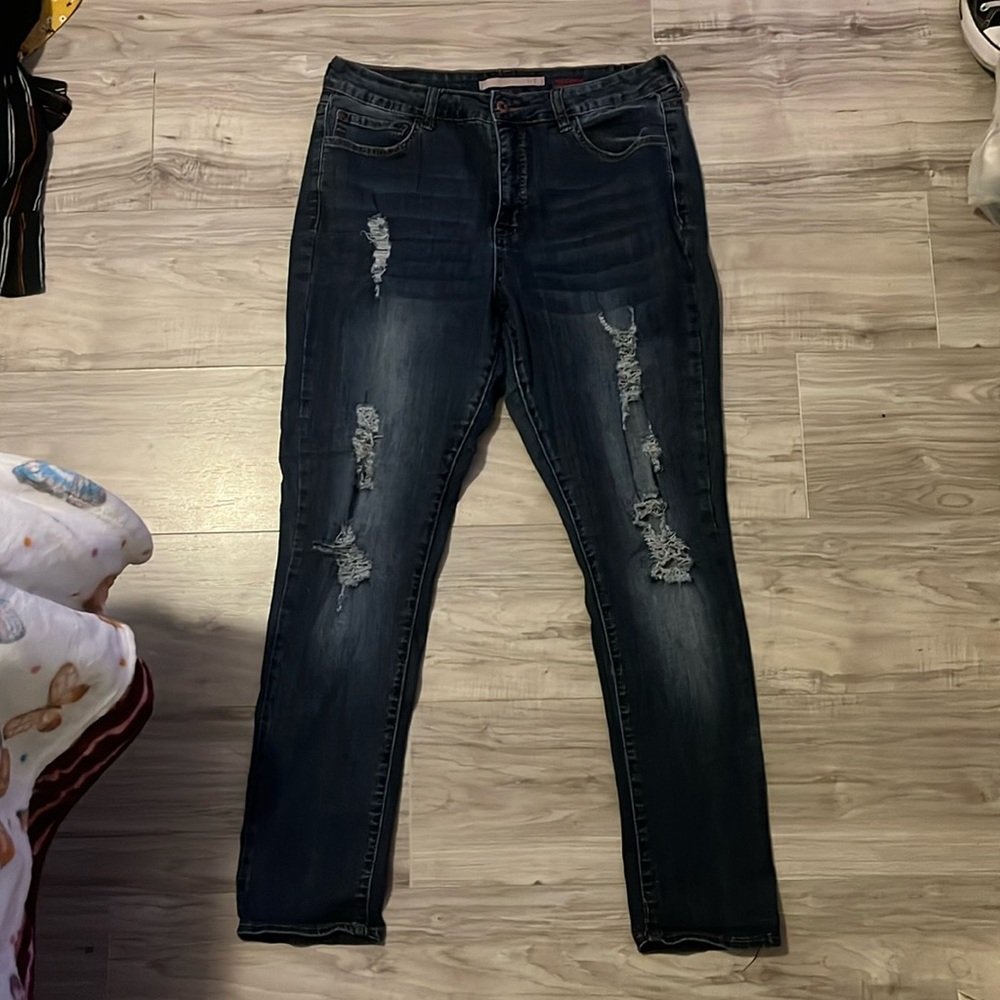 A pair of 16 size women jeans. Dark blue with rips on thighs and knees.
